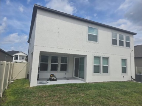Before: site photo of the house, existing lawn, fence and covered patio